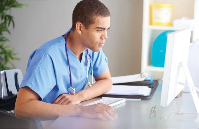 طالب طب يسترجع دروسه وينظر لجهاز كمبيوتر