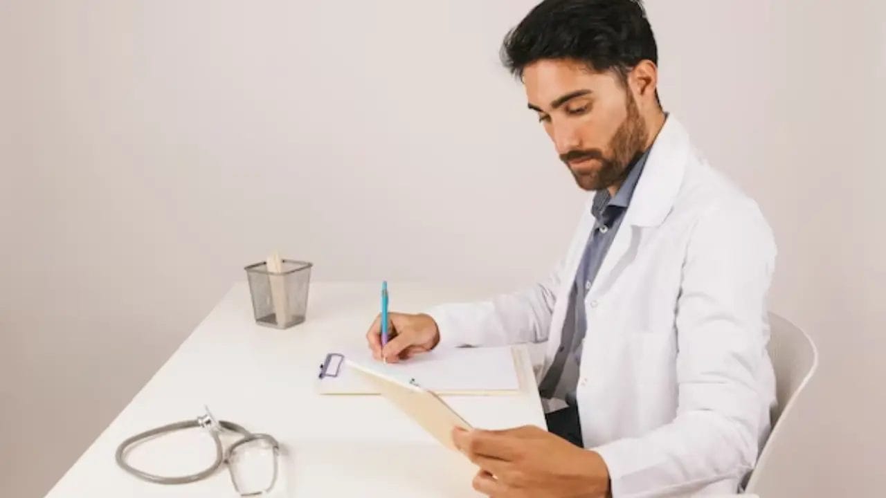 المدونة - دكتور يجلس على مكتبة ويكتب الcv الخاص به